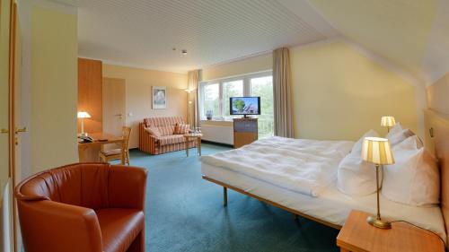 Pokój hotelowy z łóżkiem i krzesłem w obiekcie Landhotel Zur Eiche w mieście Buxtehude