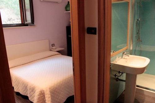 Dormitorio pequeño con cama y lavamanos en Ai Cipressi, en Salemi