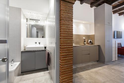 a bathroom with a brick wall and a sink at Roman Forum Suite in Rome