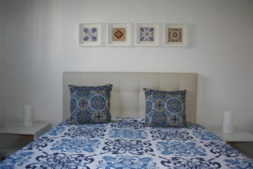 a bedroom with a blue and white bed with two pillows at Bom dia Porto in Vila Nova de Gaia