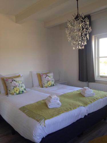 a bedroom with a large bed with towels on it at The Riverside Logies & Restaurant in Maarssen