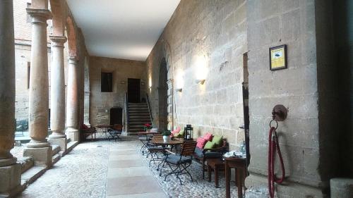 a hallway with tables and chairs in a building at Parador de Alcañiz in Alcañiz