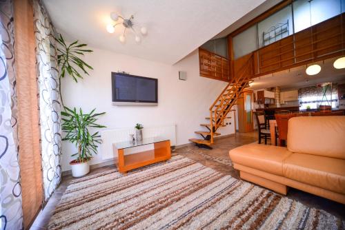 - un salon avec un canapé et une télévision dans l'établissement Apartman Ksenija, à Zadar