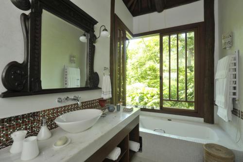 a bathroom with a sink and a tub and a window at Casa Sertão de Camburi in Camburi