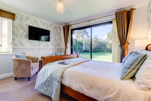 a bedroom with a large bed and a large window at Meadfoot Guesthouse Room only accommodation for Adults in Windermere