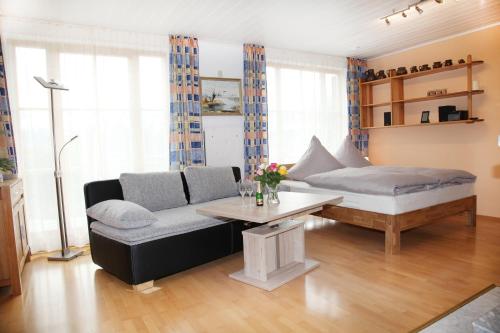 a living room with a couch and a table at Chiemsee Comfort-Bungalow mit Garten in Rimsting