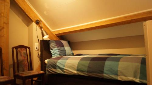 a bedroom with a bunk bed with a striped bedspread at B&B Johannes-Hoeve in Baarlo
