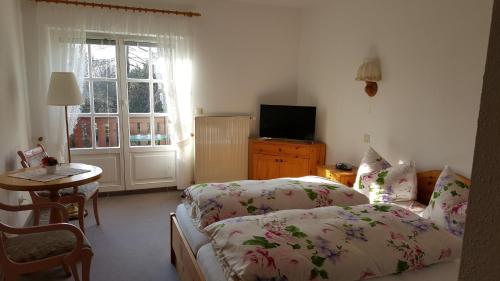 a bedroom with two beds and a table and a window at Jägerheim Löbsal in Löbsal