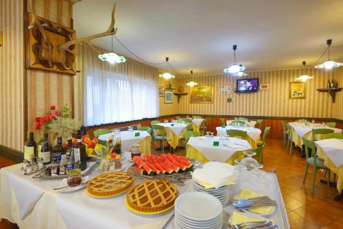 uma sala de jantar com uma mesa com comida em Hotel Holidays em Barrea