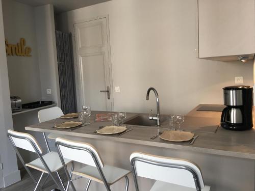 een keuken met een aanrecht met stoelen en een wastafel bij Celect'in Lyon in Lyon