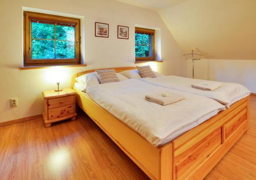ein Schlafzimmer mit einem großen Bett mit weißer Bettwäsche und einem Fenster in der Unterkunft Apartmánový domek Pod Ucháčem in Velké Losiny