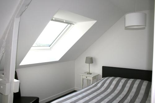 1 dormitorio con cama y ventana en La Cattevillaise, en Saint-Pair-sur-Mer
