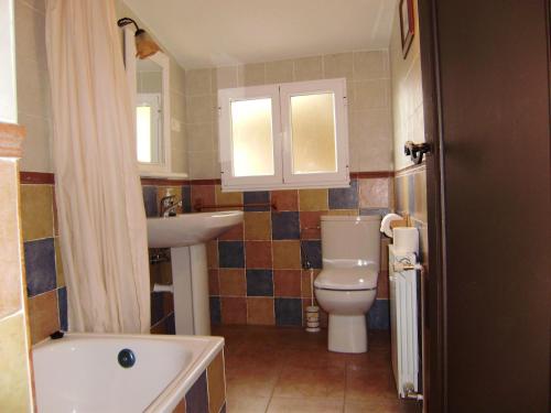 y baño con aseo, lavabo y bañera. en Casa Rural La Coja, en Villanueva del Condado