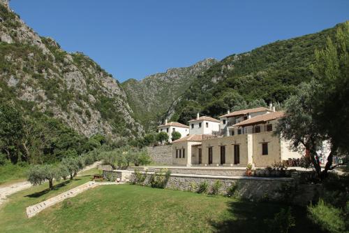 a house in the mountains with a green yard at Piges Hotel in Gliki