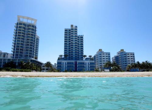 a view from the water of the beach in front of buildings at Bluebird Suites Monte Carlo Miami Beach in Miami Beach