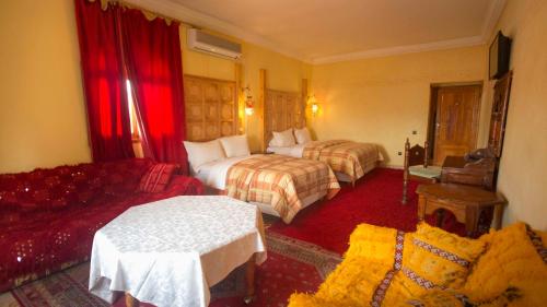 a hotel room with two beds and a couch at Hotel Kasbah Asmaa in Midelt