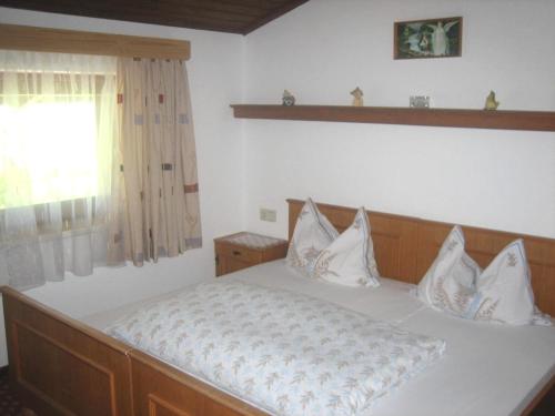 Schlafzimmer mit einem Bett mit weißer Bettwäsche und einem Fenster in der Unterkunft Funerhof in Innsbruck