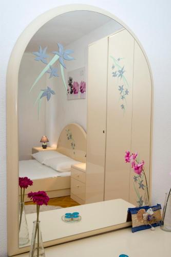 a bedroom with a mirror with blue flowers on it at Apartments Kate Postira in Postira