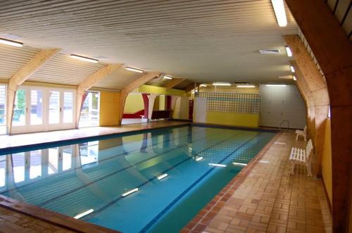 a large swimming pool in a building at L'évasion - Bungalow 102 in Durbuy
