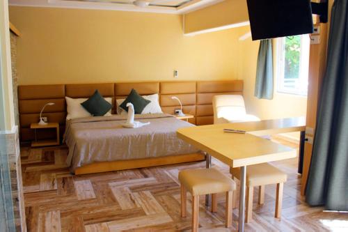a bedroom with a bed and a table and a desk at Sosua Inn Hotel in Sosúa
