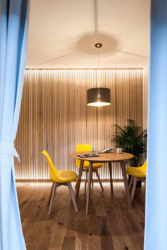 a dining room with a table and yellow chairs at Garden House in Timişoara