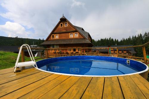 a wooden deck with a swimming pool on a house at Koliba u Kuba a rekreačné domy in Hruštín