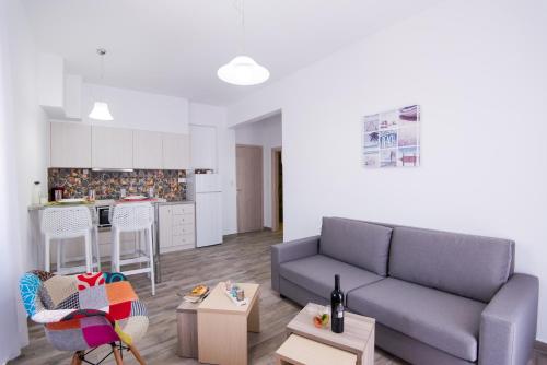 a living room with a couch and a kitchen at Breeze Vacation Apartments in Plakias