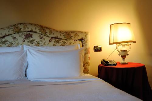 a bed with a lamp and a phone on a table at Villa Orso Grigio in Ronzone