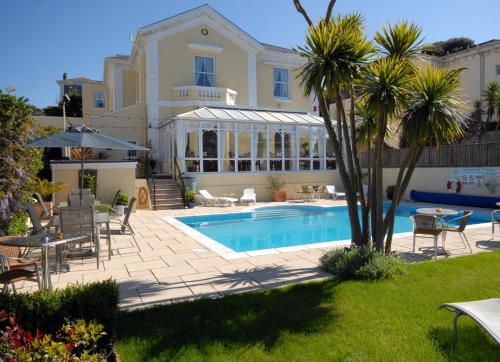 Villa con piscina en un patio en Riviera Lodge Hotel en Torquay
