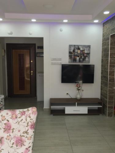 a living room with a flat screen tv on a wall at Thamer apartment in Bursa