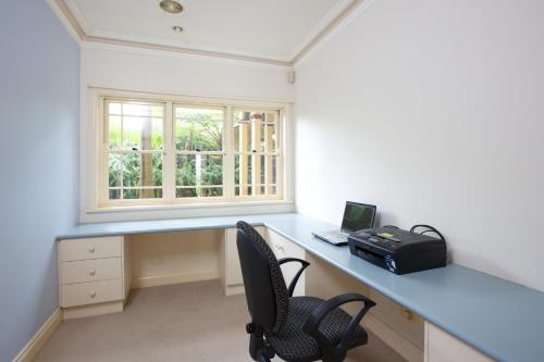 una oficina con escritorio y ventana en Tranquil Garden Hideaway, en Ormeau