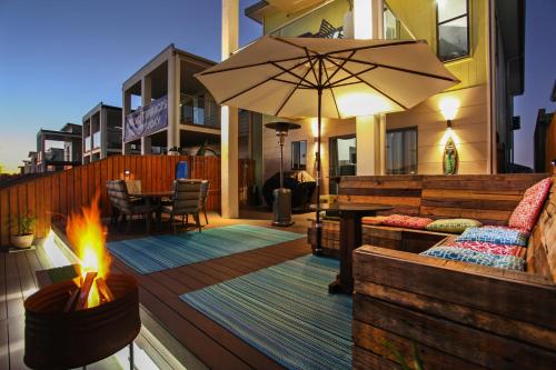 a patio with a fire pit and an umbrella at Lakeside Deck House in Mackay