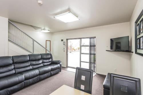 a living room with a couch and a tv at 151 On London Motel & Conference Centre in Whanganui