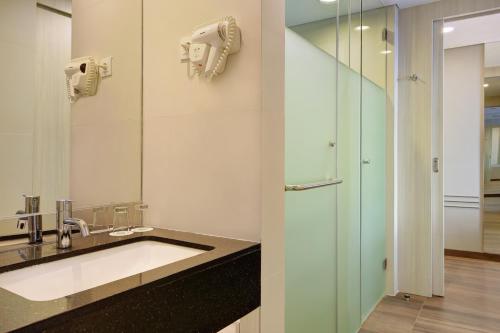 bagno con lavandino e specchio di Ibis Styles Makassar Sam Ratulangi a Makassar