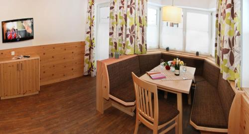 a restaurant dining room with a table and chairs at Appartements Alpenkristall in Zell am Ziller