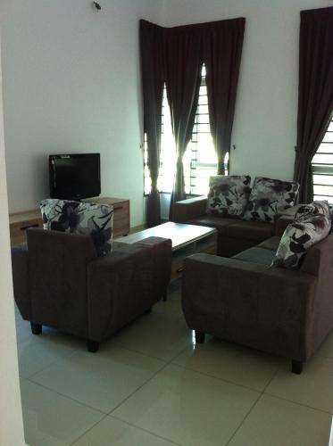 sala de estar con 2 sofás y TV en NeoHomeStay Gapam Lestari, en Melaka