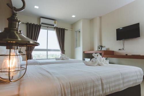 a hotel room with two beds with towels on them at deVloft hotel Korat in Nakhon Ratchasima