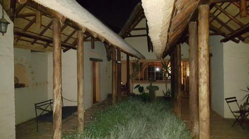 a room with wooden beams and grass in a building at African Silhouette Guesthouse in Benoni