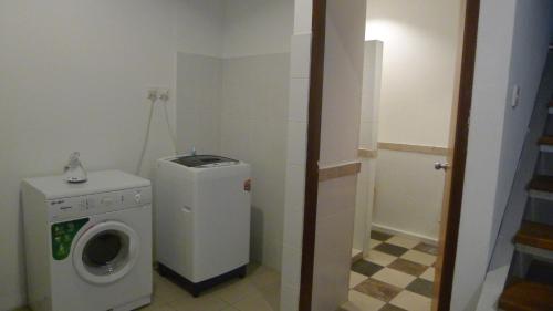 a small bathroom with a washing machine and a washer at Wesberly Apartments in Kuching