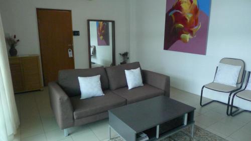 a living room with a couch and a table and a chair at Wesberly Apartments in Kuching