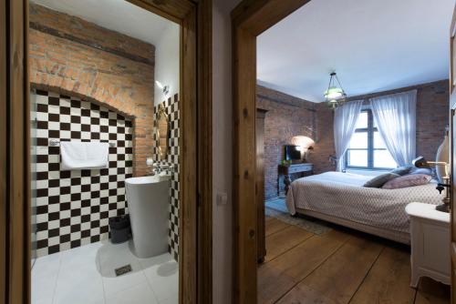 a bedroom with a brick wall and a bed and a bathroom at Casa Veche in Braşov