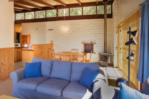 een woonkamer met een blauwe bank en een tafel bij Bombina Cottages in Denmark