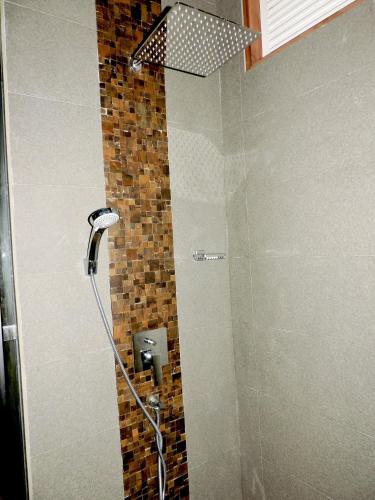 a bathroom with a shower with a glass door at Ballena Regency in Mirissa
