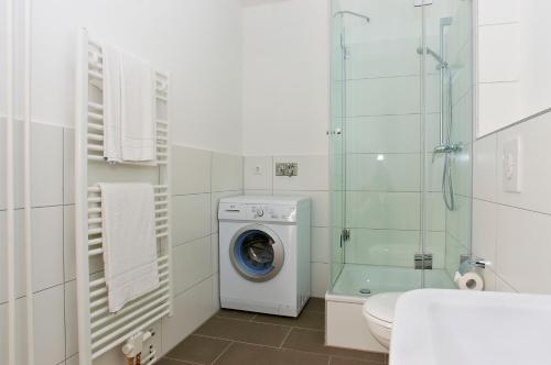 ein weißes Bad mit einer Waschmaschine in der Unterkunft Apartmenthouse Berlin - Am Görlitzer Park in Berlin