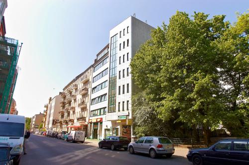 a city street with cars parked in front of a tall building at Apartmenthouse Berlin - Am Görlitzer Park in Berlin