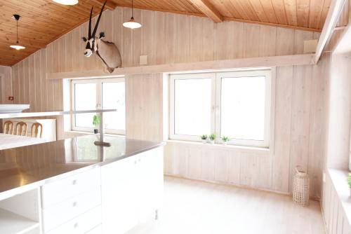 cocina con armarios blancos y 2 ventanas en Per Gynt Lodge, en Vinstra
