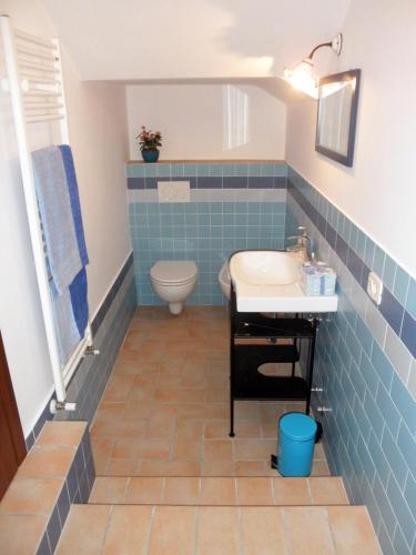 a blue tiled bathroom with a sink and a toilet at Agriturismo Fonte Carra in Grottazzolina