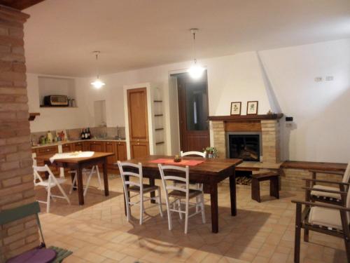 a kitchen and dining room with a table and a fireplace at Agriturismo Fonte Carra in Grottazzolina