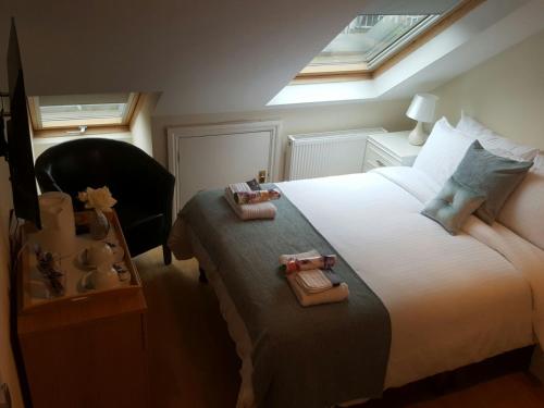 a bedroom with a large white bed with two bags on it at Kathleen House in Enfield