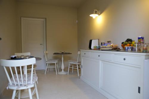 a kitchen with a table, chairs and a refrigerator at Avion B&B in Cagliari